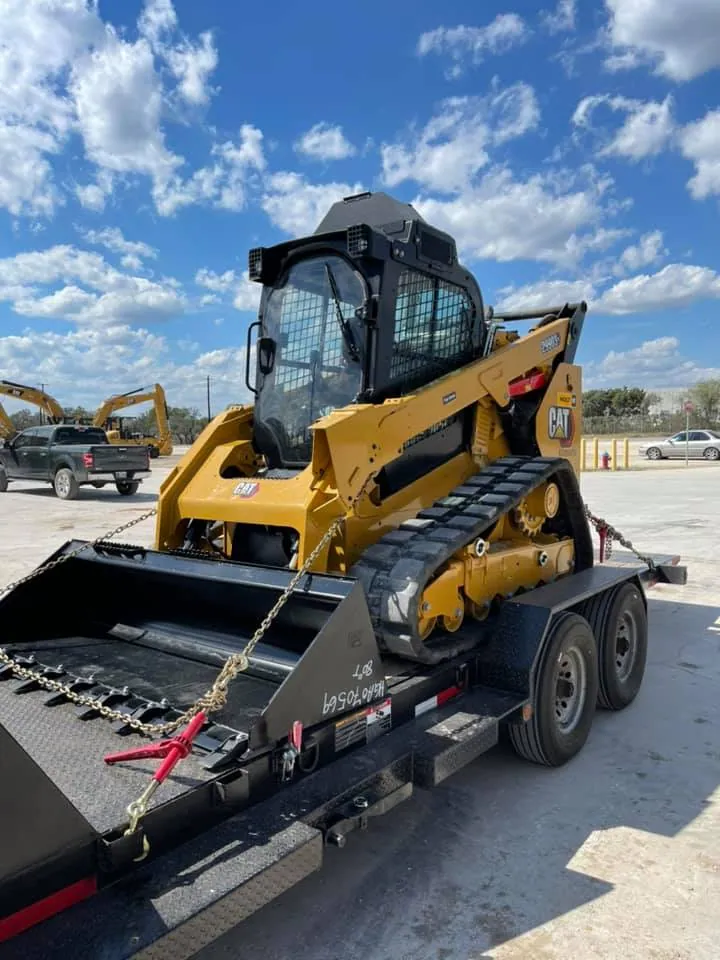 Tracked skid steer chained down on a gooseneck trailer